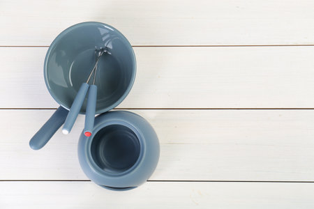 Fondue set on white wooden table, flat lay. Space for textの写真素材