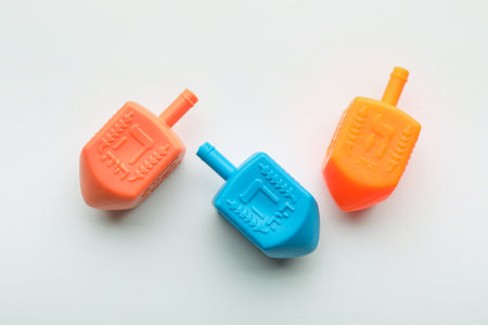Colorful dreidels on white background, flat lay. Traditional Hanukkah game