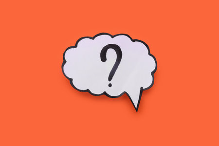 Paper speech bubble with question mark on orange background, top viewの写真素材