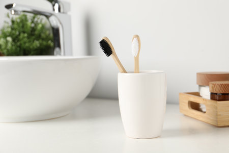 Bamboo toothbrushes on white countertop in bathroomの写真素材