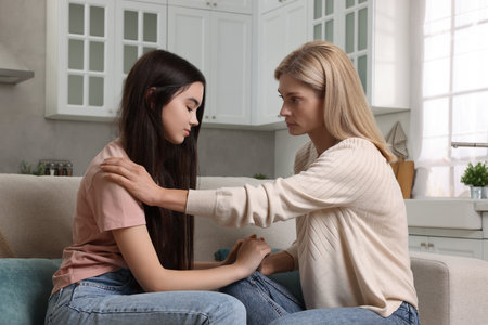 Mother consoling her upset daughter at home. Teenager problems