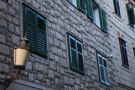 View of building with wooden shutters on windows and street lampの写真素材