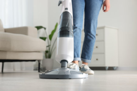 Woman cleaning floor with steam mop at home, closeupの写真素材