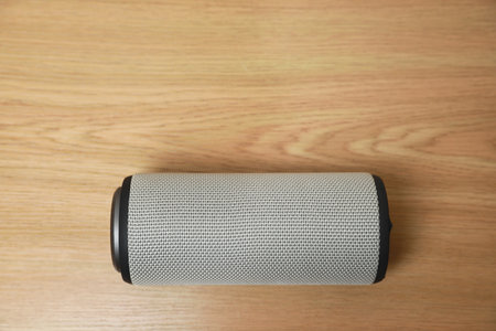 One portable bluetooth speaker on wooden table, top view with space for text. Audio equipmentの写真素材