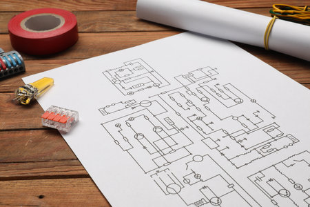 Wiring diagram, different electrician's equipment and insulating tape on wooden tableの写真素材