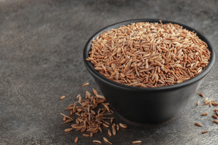 Bowl of caraway seeds on gray table, closeup. Space for textの写真素材