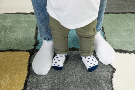 Mother with her son standing on soft carpet, closeupの写真素材