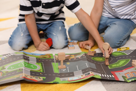 Little children playing with set of wooden road signs and toy cars indoors, closeupの写真素材
