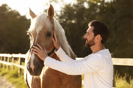 Handsome man with adorable horse outdoors. Lovely domesticated petの写真素材