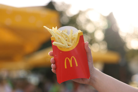 Lviv, Ukraine - September 26, 2023: Woman with McDonald's French fries outdoors, closeup