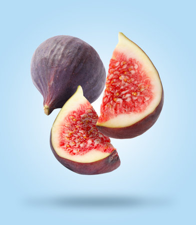 Fresh figs falling on light blue background
