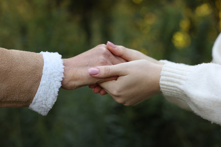 Trust and support. Women joining hands outdoors, closeup