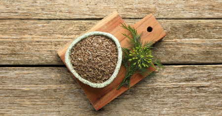Dill seeds in bowl on wooden table, top view. Banner design