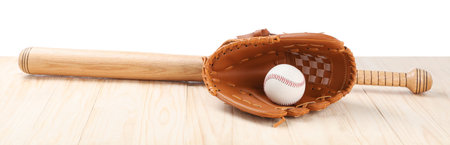 Baseball bat, ball and catcher's mitt on wooden table against white backgroundの写真素材