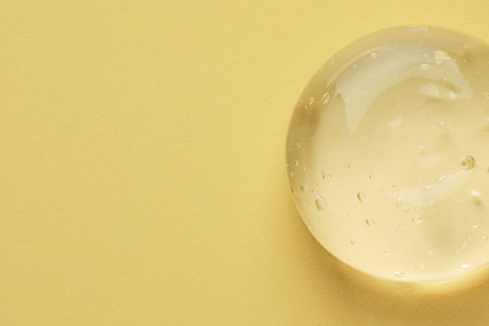 Sample of clear cosmetic gel on yellow background, top view. Space for textの写真素材