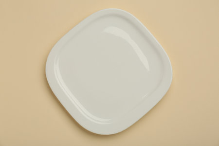 Beautiful ceramic plate on beige background, top viewの写真素材