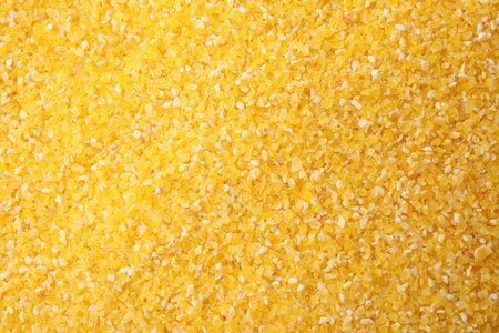 Raw corn grits as background, top view