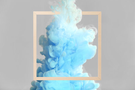 Splash of light blue ink and frame on gray background