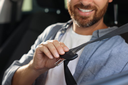 Man pulling seat belt in car, closeup