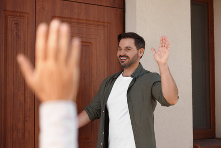 Friendly relationship. Neighbors greeting each other near house outdoorsの写真素材