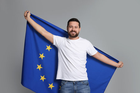 Man holding European Union flag on light gray backgroundの写真素材