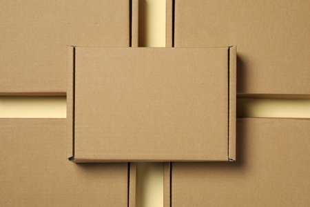 Many closed cardboard boxes on pale yellow background, flat lay