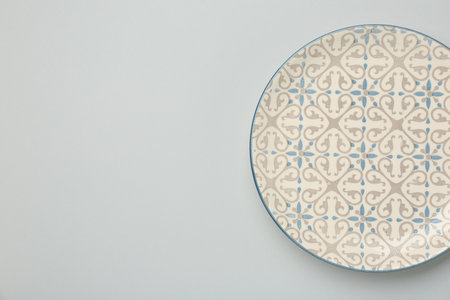 Beautiful ceramic plate on light background, top view. Space for text