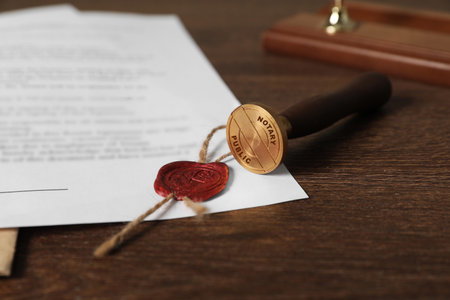 Public notary. Document with wax stamp on wooden table, closeup