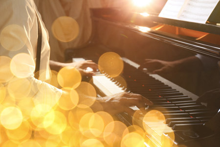 Christmas and New Year music. Man playing piano, closeup. Bokeh effectの写真素材