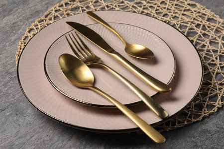 Stylish table setting with cutlery on gray surface, closeup