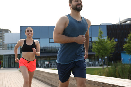 Healthy lifestyle. Happy couple running outdoors on sunny day