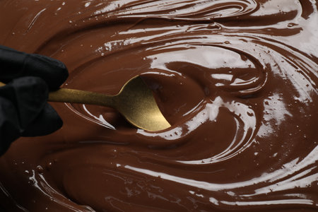 Person making tasty milk chocolate paste, closeup