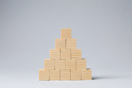 Pyramid of blank wooden cubes on light gray background