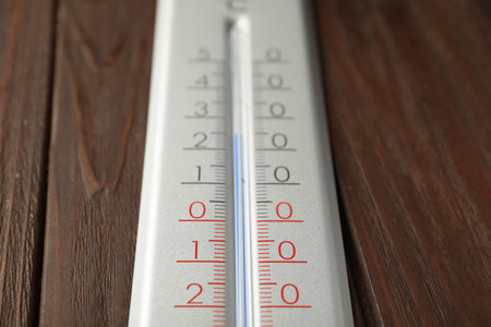 Modern weather thermometer on wooden background, closeup
