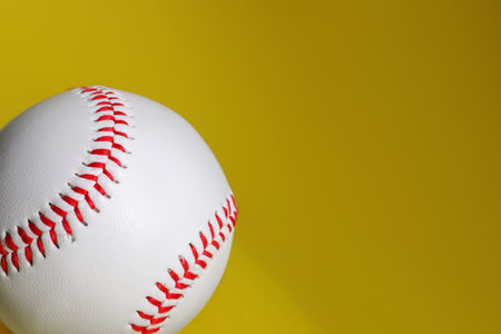 One baseball ball on yellow background, closeup. Space for textの写真素材