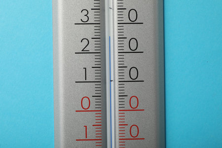 Weather thermometer on light blue background, closeup