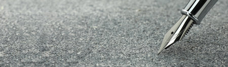 Fountain pen on gray textured table, closeup. Banner design with space for textの写真素材