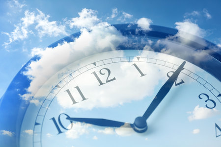 Time concept. Double exposure of blue sky with fluffy clouds and clock