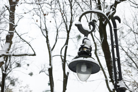 Beautiful street light with snow against sky in winter, space for text
