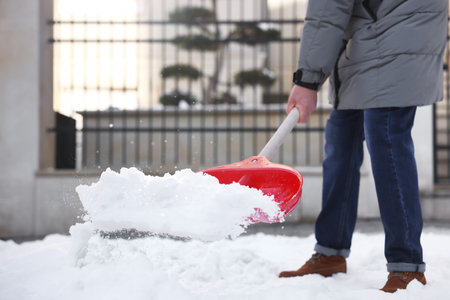 Man removing snow with shovel outdoors, closeupの写真素材
