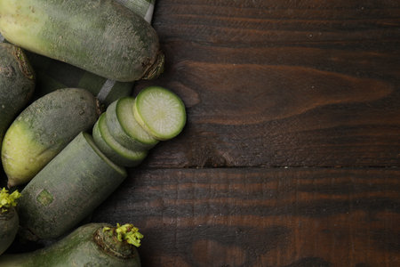 Green daikon radishes on wooden table, flat lay. Space for textの写真素材