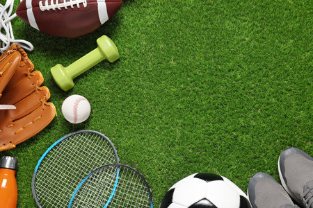 Different sport tools on green grass, flat lay. Space for textの写真素材
