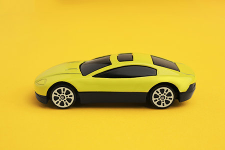 One bright car on yellow background. Children's toy