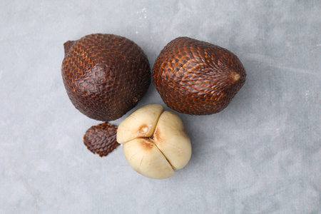 Fresh salak fruits on light gray table, flat lay