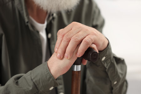 Senior man with walking cane on blurred background, closeupの写真素材