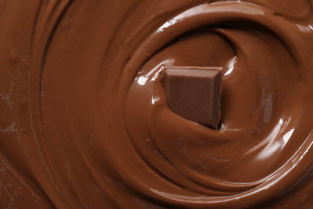 Tasty milk chocolate paste and piece as background, top view