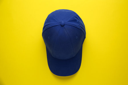 Stylish blue baseball cap on yellow background, top viewの写真素材