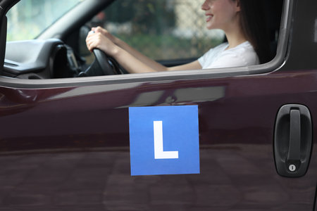 Learner driver driving car with L-plate, view from outside. Driving schoolの写真素材