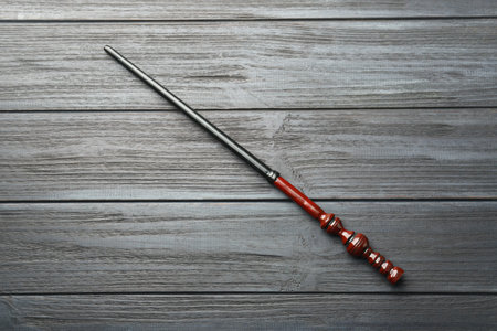 One old magic wand on gray wooden table, top view