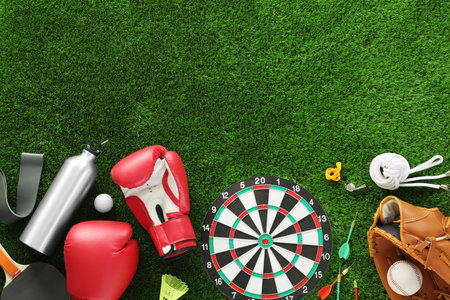 Different sport equipment on green grass, flat lay. Space for textの写真素材
